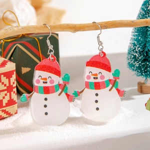 Detailed close-up of resin snowman earrings with festive glitter on a Christmas branch