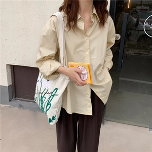 Chic beige long-sleeve shirt paired with a chamomile floral canvas tote bag in daily use