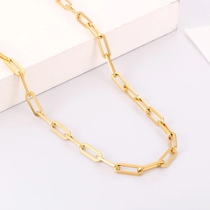 Close-up of golden paperclip link chain necklace with polished geometric finish
