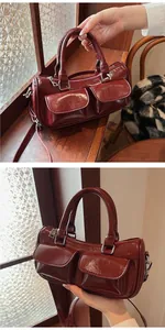 Deep red glossy leather cylindrical bag with functional flap pockets and silver hardware