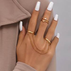 Detailed view of layered gold finger bracelet rings with chain link on model hand