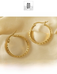 Detail of large 18K gold plated titanium steel hoop earrings with twisted rope texture