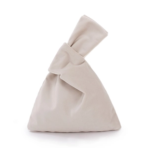 Détail d'un sac à main en velours beige avec une poignée nouée au design élégant