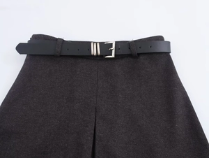 Detail of dark grey herringbone wool skirt with a black leather belt and silver buckle