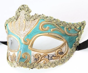 Close-up of a teal and gold Venetian masquerade mask with ornate lace and music score detail