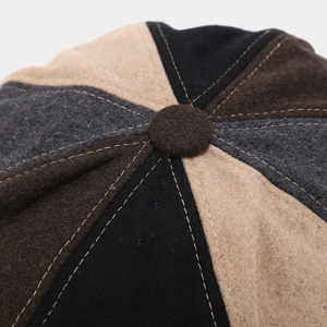 Top view of patchwork newsboy cap showing wool blend texture and central button detail
