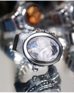 Macro detail of vintage silver ring watch featuring a white cameo relief on clear gemstone