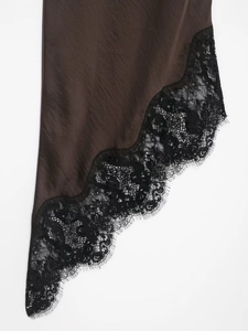 Detail of dark brown satin fabric with intricate black lace trim on an asymmetric dress