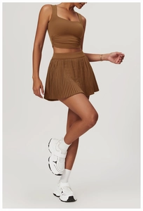 Detail of caramel high-waist pleated tennis skirt and ruched square neck sports vest
