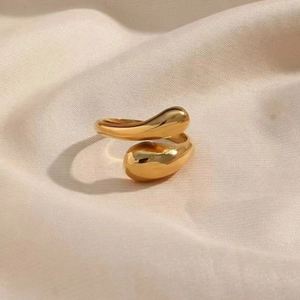 Minimalist gold adjustable teardrop ring on satin fabric, modern polished wrap jewelry