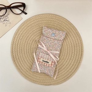 Close-up of floral fabric glasses pouch with blue snap button and pink ribbon bow detail