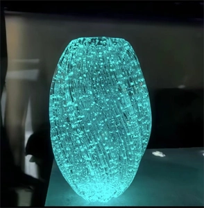 Detail of luminous glass vase with bubble texture and soft blue glow in dark lighting