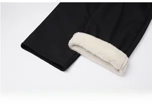Dettaglio dei pantaloni neri con fodera in pile sherpa bianco e polsini alle caviglie
