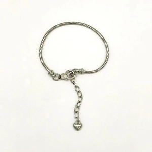 Silver snake chain bracelet with heart pendant and lobster clasp on white background