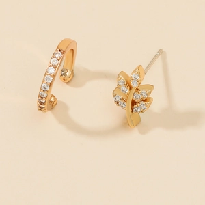 Detailed shot of asymmetric gold leaf earrings with sparkling cubic zirconia pavé