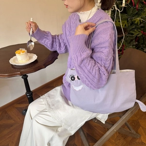 Detail of cute cat embroidery on light purple canvas tote bag with warm tea time setting