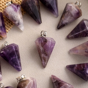 Macro shot of faceted natural amethyst cone pendants with silver plated metal bails