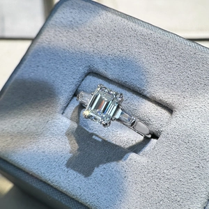S925 sterling silver ring with 2-carat emerald cut moissanite in a grey velvet jewelry box