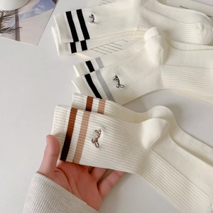 Detailed close-up of ribbed knit cotton socks with stripe pattern and smile embroidery