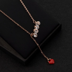 Gros plan du pendentif 314 en or rose 18K avec cœur rouge sur socle noir chic