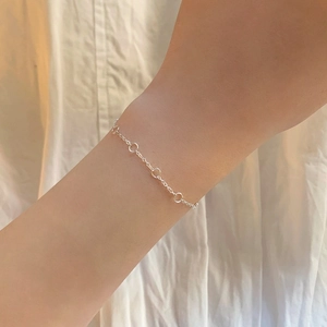 Minimalist S925 sterling silver circle knot bracelet on model wrist with white background
