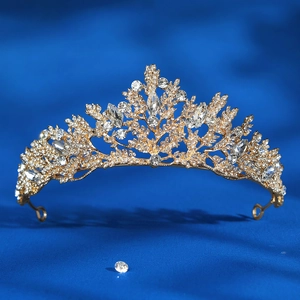 Close-up of golden bridal crown with intricate leaf designs and sparkling crystals