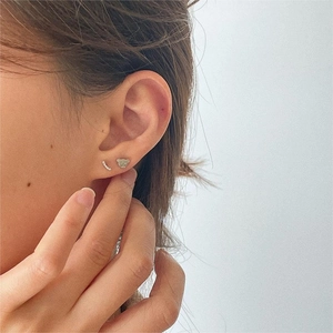 Detailed view of sterling silver bear stud earring and curved diamond row on ear