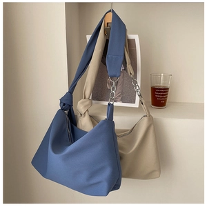 Detail showing soft canvas crossbody bags with unique knotted straps and silver metal chains