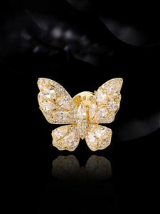 Close-up of golden butterfly brooch with pear-cut crystals and sparkling pavé stones