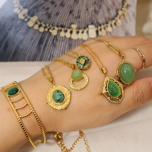 Macro shot of 18K gold plated jewelry set featuring malachite green stone pendants