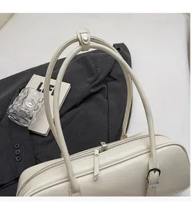 Detail of off-white baguette bag showing high-quality leather texture and dual zippers
