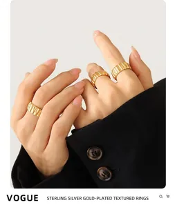 Close-up of three 18K gold-plated ribbed croissant rings stacked on model's fingers