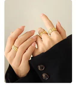 Close-up of three 18K gold-plated ribbed croissant rings stacked on model's fingers