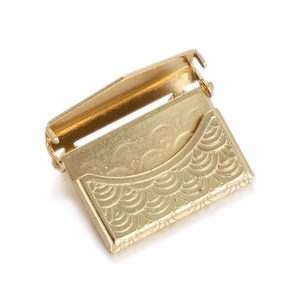 Detailed view of a gold-plated heart hexagonal locket with engraved wave pattern