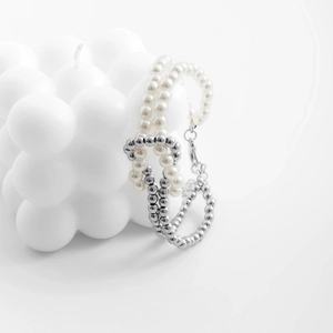Detailed close-up of beaded bracelet with pearls and silver metallic round beads