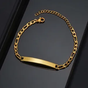 Macro shot of gold plated Figaro ID bracelet featuring a curved engraving plate on black background