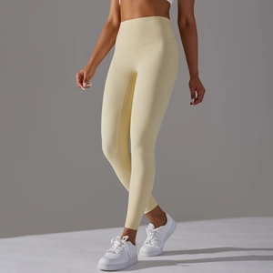 Detail view of high waist buttery soft yoga leggings in cream yellow with seamless design
