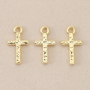 Macro view of 18K gold plated Baroque cross pendants with hammered bark texture