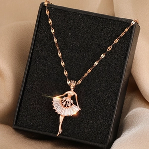 Close-up of rose gold ballerina pendant with sparkling crystals on beige silk