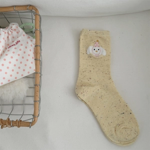Detail of yellow knit sock featuring a cute white bear embroidery with a pink birthday hat