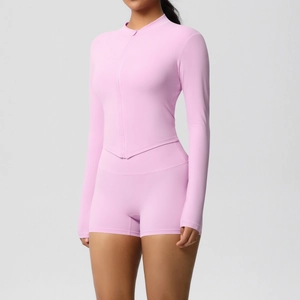 Detail of light pink slim fit yoga set featuring zipper long sleeve top and athletic shorts