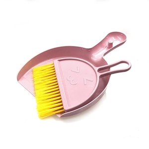 Detail of pink mini dustpan and yellow brush set with smiley face and hanging hole