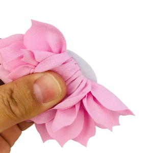 Detail of pink fabric lotus hair flower showing layered petals and soft texture