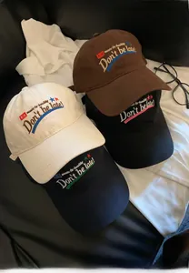 Close-up of four colored vintage baseball caps with detailed letter embroidery on top