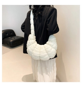 Detailed back view of a white quilted cloud bag styled with modern minimalist decor
