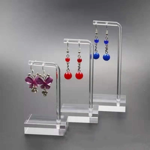 Three-piece clear acrylic earring display stands in a tiered layout for jewelry storage