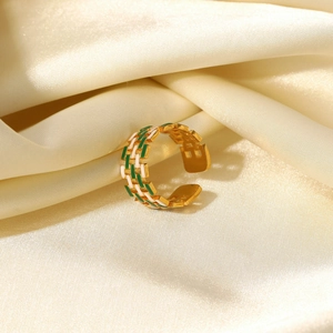Detail of 18K gold-plated ring with green and white enamel on satin fabric