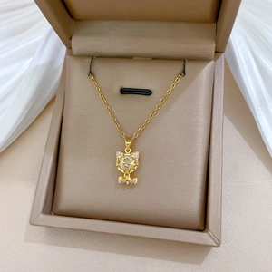 Close-up of gold titanium necklace with hollow cat pendant in a luxury jewelry box