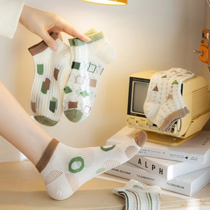 Close-up of women's bamboo fiber socks with geometric patterns in a cozy vintage setting