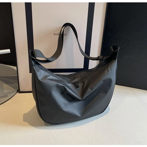 Detail of black waterproof dumpling bag showing smooth matte texture and adjustable strap